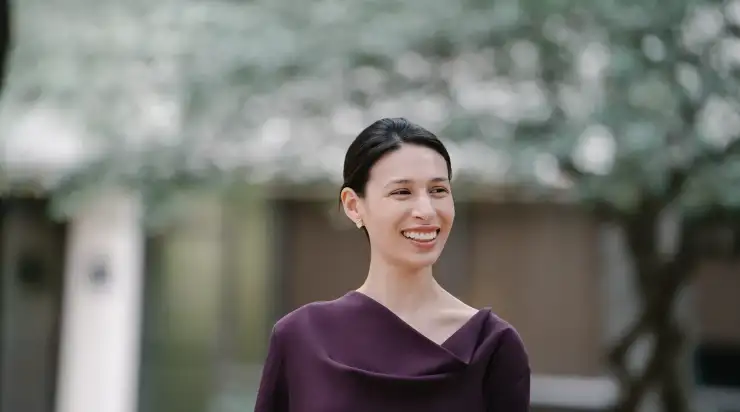 Candid, lifestyle-style headshot of a woman in a maroon dress, smiling and looking off to the side—often captured during branding photography sessions for use on websites, social media, and advertising to showcase personality and approachability.